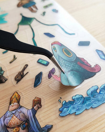 Tweezers placing stickers on a canvas scene